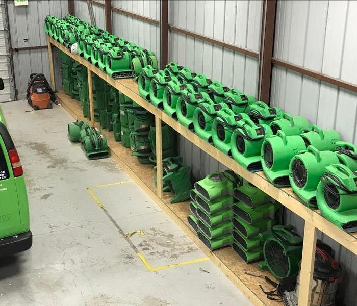 green equipment on shelves in warehouse