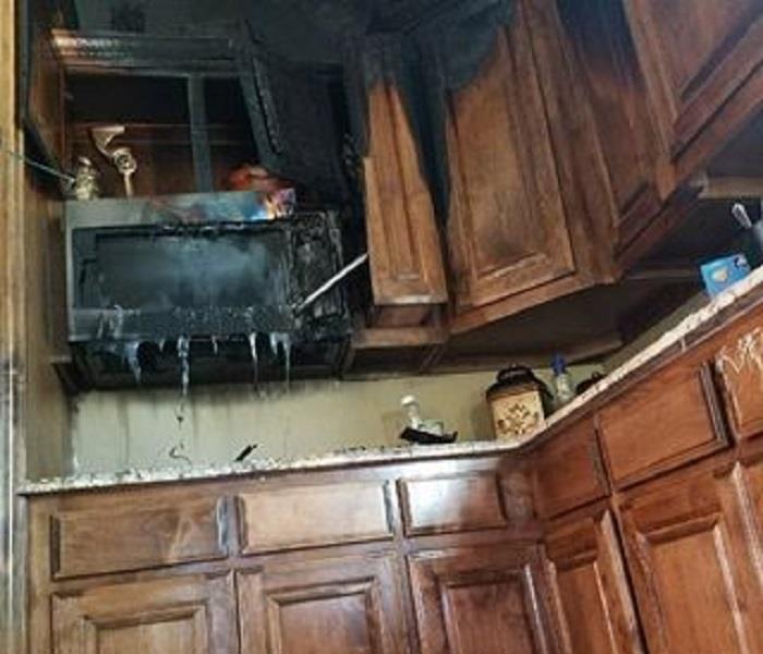 Kitchen cabinets and microwave damaged in a fire