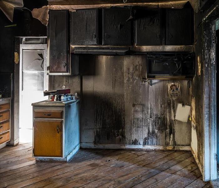 Kitchen affected by fire damage with smoke and soot up walls
