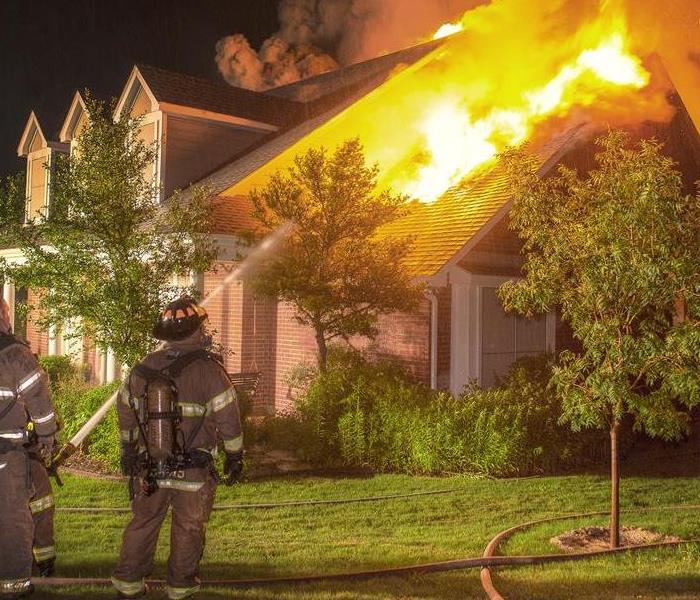 House fire with firefighters extinguishes with water hose